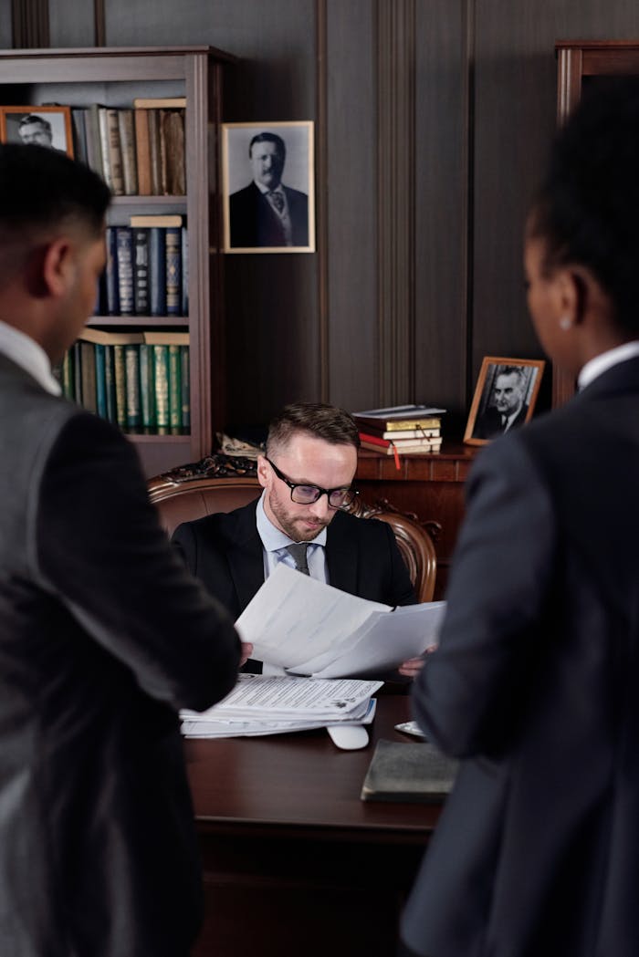 Business professionals discussing important legal documents in an office setting.